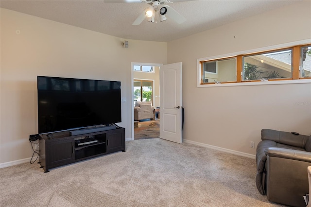 carpeted living area with ceiling fan and baseboards