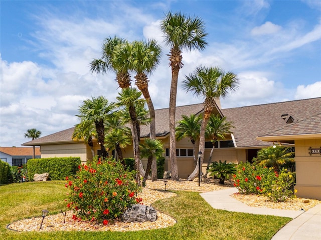view of front of home featuring a garage, a front yard, and roof with shingles