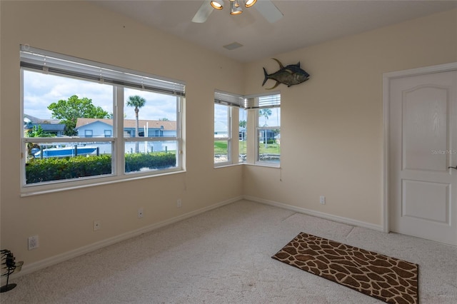 empty room featuring a ceiling fan, carpet flooring, and baseboards