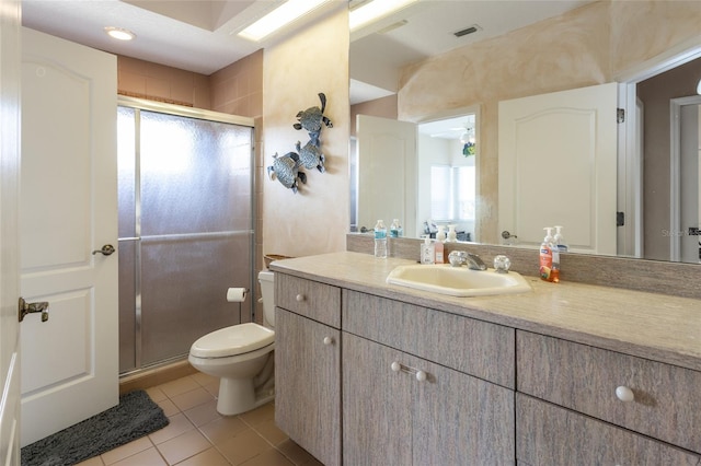 bathroom with tile patterned floors, toilet, vanity, visible vents, and a stall shower