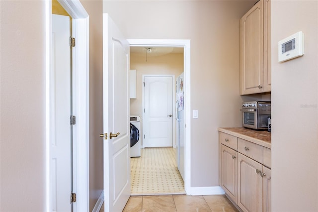 laundry area featuring cabinet space, a toaster, washer / clothes dryer, and baseboards