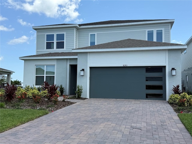 8243 Fenton St, Orlando, FL 32836 - view of front of house featuring decorative driveway, an attached garage, a shingled roof, and stucco siding