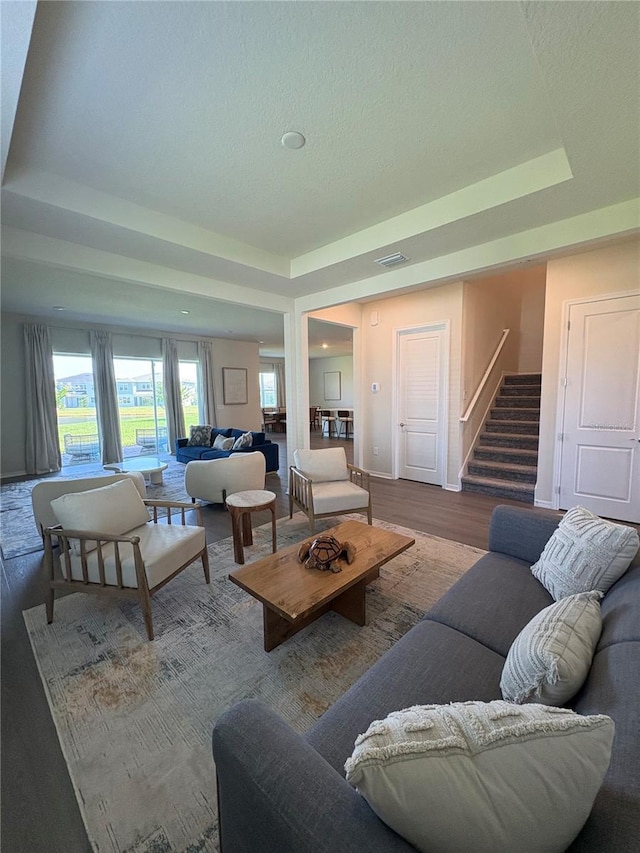 8243 Fenton St, Orlando, FL 32836 - living area with a tray ceiling, stairway, wood finished floors, and a textured ceiling