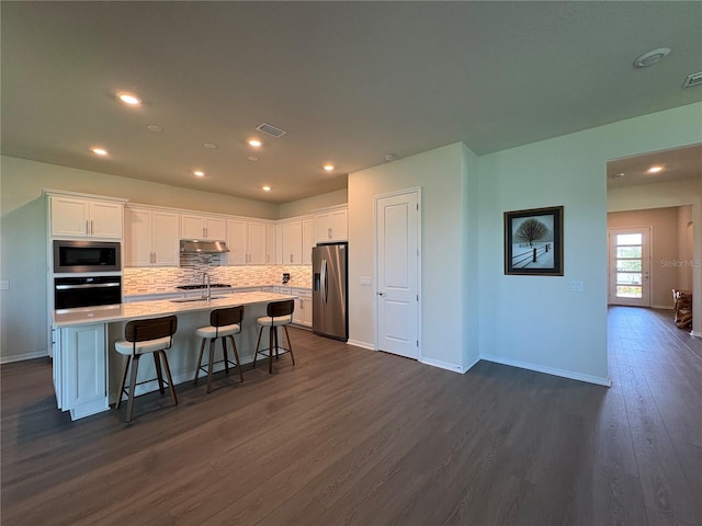 8243 Fenton St, Orlando, FL 32836 - kitchen featuring stainless steel appliances, dark wood-type flooring, white cabinets, light countertops, and tasteful backsplash