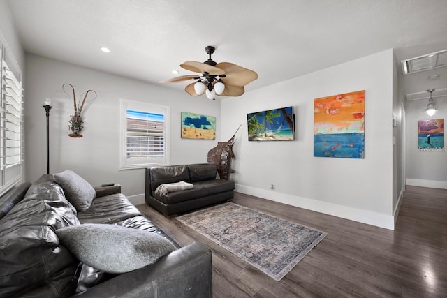 living room with attic access, baseboards, visible vents, ceiling fan, and wood finished floors