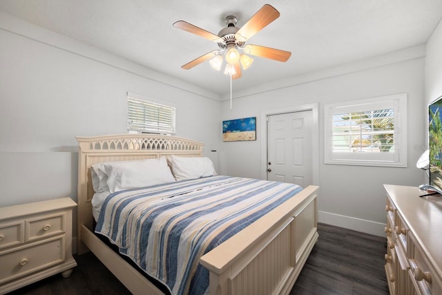 bedroom with baseboards, ceiling fan, a closet, and dark wood finished floors