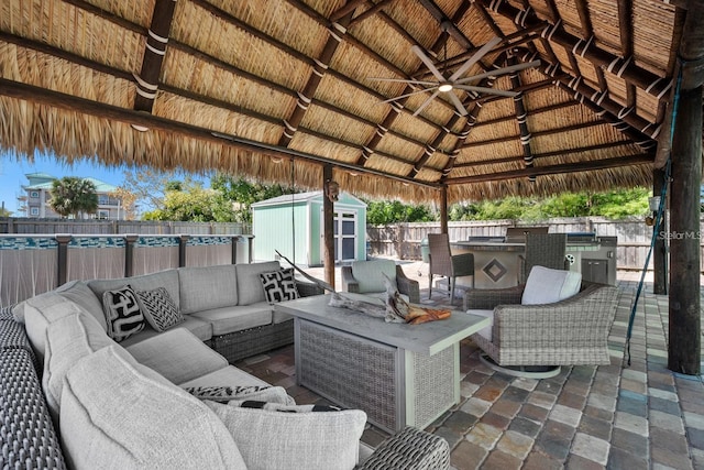 view of patio / terrace featuring an outdoor hangout area, a fenced backyard, outdoor dry bar, an outbuilding, and a shed
