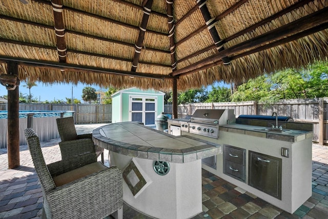 view of patio with a grill, a gazebo, an outdoor structure, a storage shed, and a fenced backyard