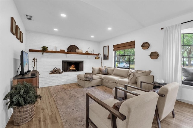 1558 Regal Oak Dr, Kissimmee, FL 34744 - living room featuring a brick fireplace, recessed lighting, visible vents, and light wood-type flooring