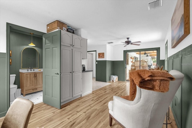 1558 Regal Oak Dr, Kissimmee, FL 34744 - interior space featuring visible vents, light wood-style floors, ceiling fan, a wainscoted wall, and a sink