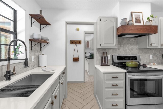 1558 Regal Oak Dr, Kissimmee, FL 34744 - kitchen featuring light countertops, electric range, decorative backsplash, and a sink