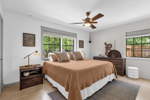 1558 Regal Oak Dr, Kissimmee, FL 34744 - bedroom with wooden walls, a ceiling fan, and light wood-style flooring