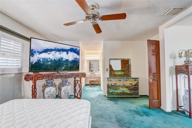 carpeted bedroom featuring a ceiling fan, visible vents, and a textured ceiling
