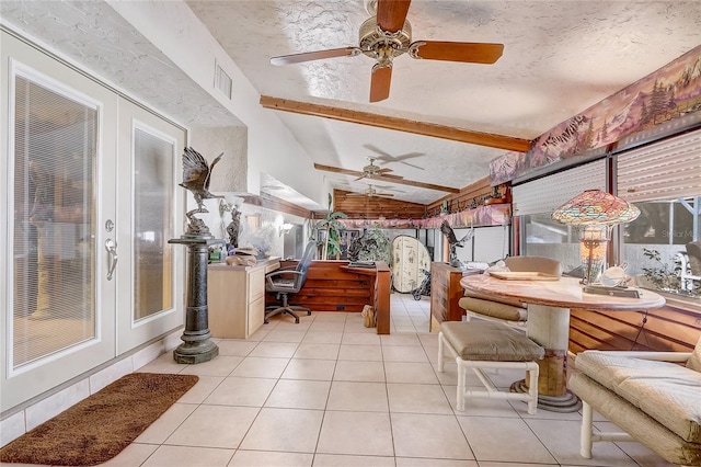 sunroom / solarium featuring a textured ceiling, beam ceiling, tile patterned flooring, and visible vents