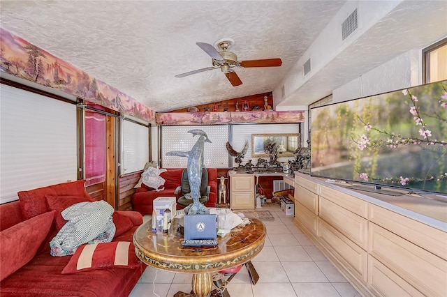 sunroom featuring vaulted ceiling, visible vents, tile patterned flooring, and ceiling fan