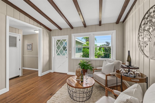 interior space featuring beam ceiling, baseboards, and wood finished floors
