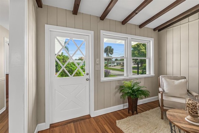 interior space featuring beam ceiling, baseboards, and wood finished floors