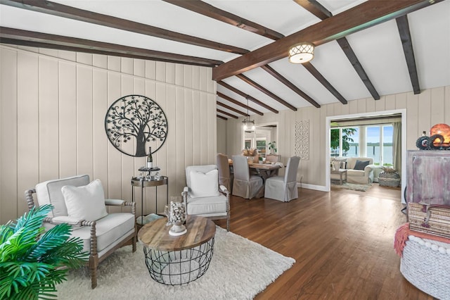 sitting room with lofted ceiling with beams and wood finished floors