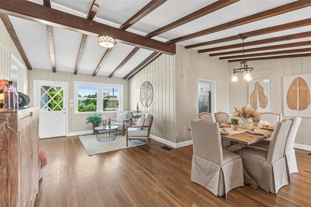 dining space featuring vaulted ceiling with beams, baseboards, and wood finished floors