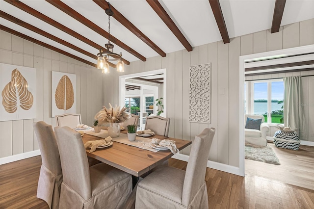 dining area with an inviting chandelier, lofted ceiling with beams, baseboards, and wood finished floors