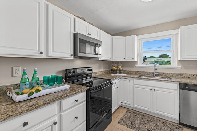 kitchen featuring white cabinets, a sink, appliances with stainless steel finishes, and stone countertops