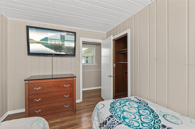 bedroom with dark wood-type flooring and baseboards