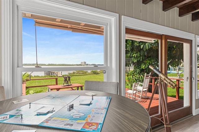 interior space featuring a water view, beamed ceiling, and plenty of natural light