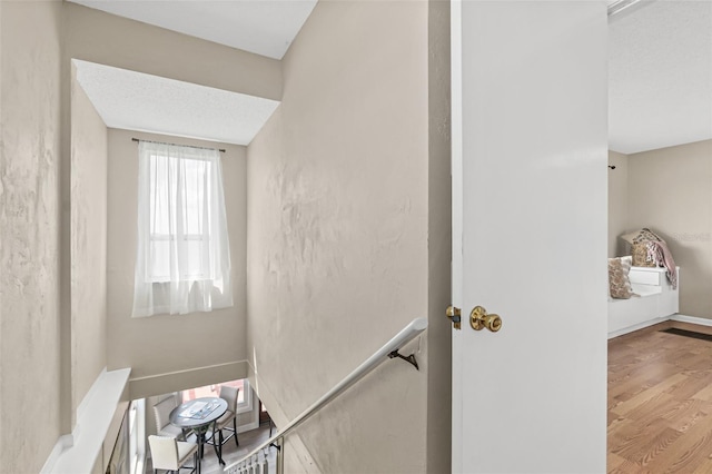 stairway with baseboards and wood finished floors