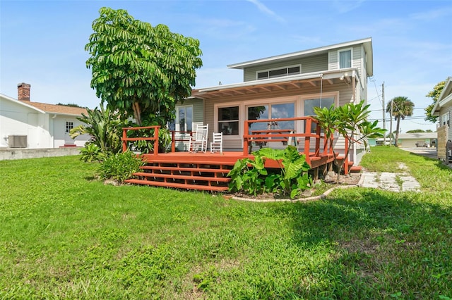 back of property with a yard and a wooden deck