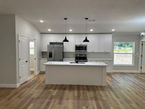 kitchen featuring light countertops, appliances with stainless steel finishes, baseboards, and white cabinetry