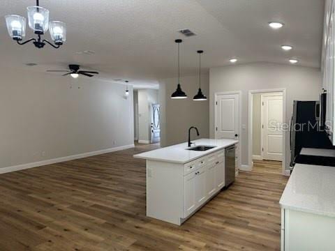 kitchen with a sink, recessed lighting, white cabinetry, wood finished floors, and ceiling fan with notable chandelier