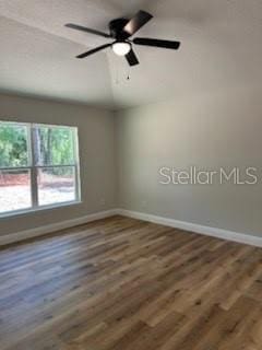 unfurnished room with baseboards, a ceiling fan, and wood finished floors