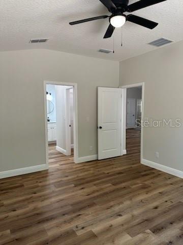 unfurnished bedroom with visible vents, baseboards, wood finished floors, and a textured ceiling