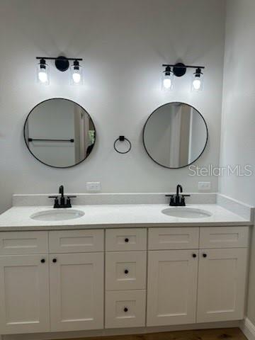 full bath with a sink and double vanity