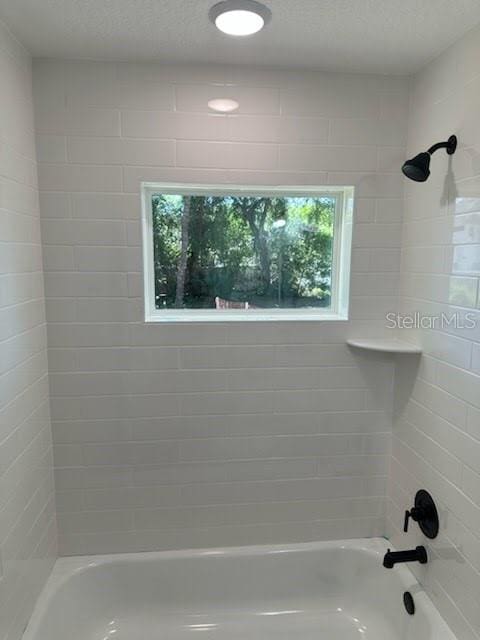 full bath featuring shower / bathing tub combination and a textured ceiling