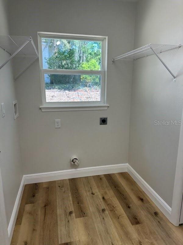 laundry area with laundry area, baseboards, hookup for a washing machine, and electric dryer hookup