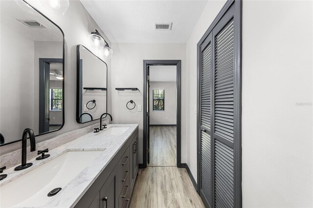 bathroom with visible vents, a closet, wood finished floors, and a sink