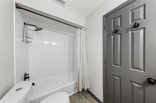 bathroom featuring visible vents, wood finished floors, toilet, and shower / bath combination with curtain