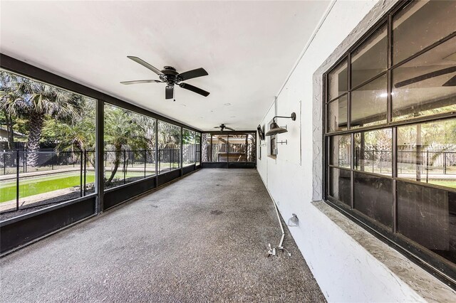 unfurnished sunroom with ceiling fan