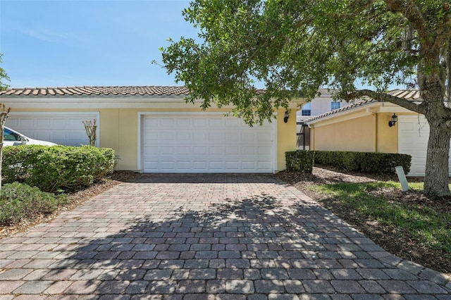 8639 Lower Villagewalk Cir, Orlando, FL 32827 - view of front facade with stucco siding, a tile roof, and decorative driveway