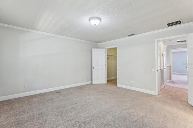 8639 Lower Villagewalk Cir, Orlando, FL 32827 - unfurnished bedroom featuring ornamental molding, light colored carpet, baseboards, a spacious closet, and a textured ceiling