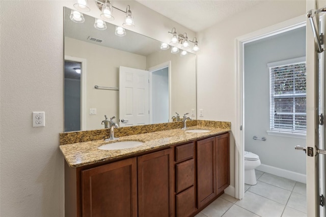 8639 Lower Villagewalk Cir, Orlando, FL 32827 - bathroom featuring double vanity, toilet, and tile patterned flooring