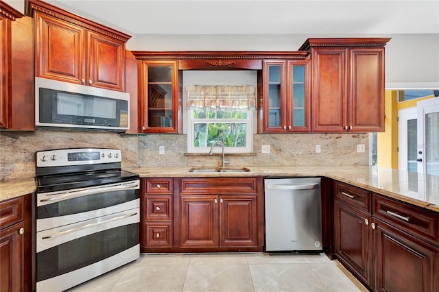 12706 Magnolia Bay Blvd, Clermont, FL 34711 - kitchen with appliances with stainless steel finishes, backsplash, light stone counters, and reddish brown cabinets