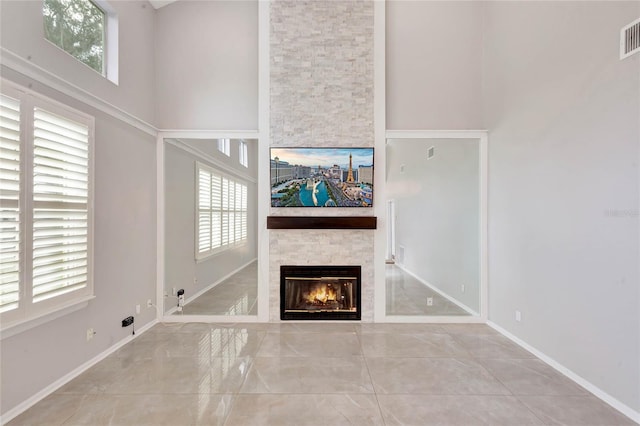 12706 Magnolia Bay Blvd, Clermont, FL 34711 - unfurnished living room with a stone fireplace, healthy amount of natural light, and a high ceiling