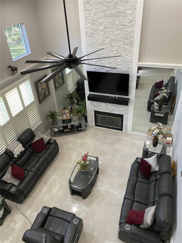 12706 Magnolia Bay Blvd, Clermont, FL 34711 - living room with a ceiling fan, a stone fireplace, a high ceiling, and tile patterned floors
