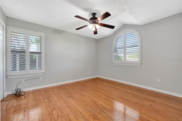 12706 Magnolia Bay Blvd, Clermont, FL 34711 - empty room with wood finished floors, ceiling fan, lofted ceiling, and a textured ceiling