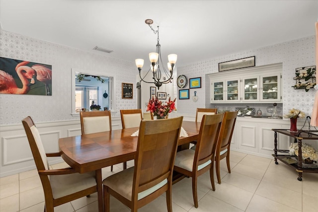 11160 SE 47th Ave, Belleview, FL 34420 - dining space featuring light tile patterned flooring, visible vents, a chandelier, wallpapered walls, and wainscoting