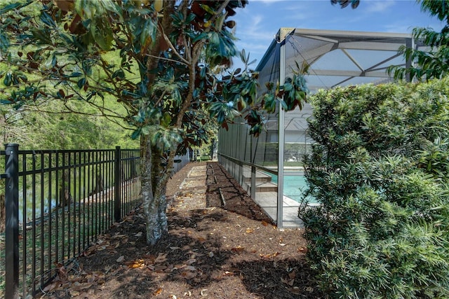 exterior space featuring a fenced backyard, glass enclosure, and a fenced in pool