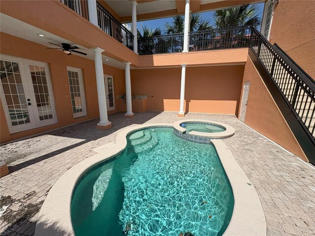 view of swimming pool featuring a patio, a pool with connected hot tub, french doors, and ceiling fan