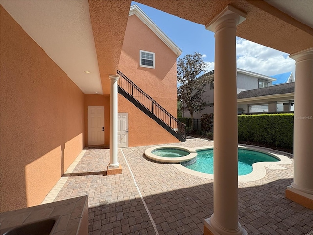 view of swimming pool with stairs, a pool with connected hot tub, a patio area, and fence